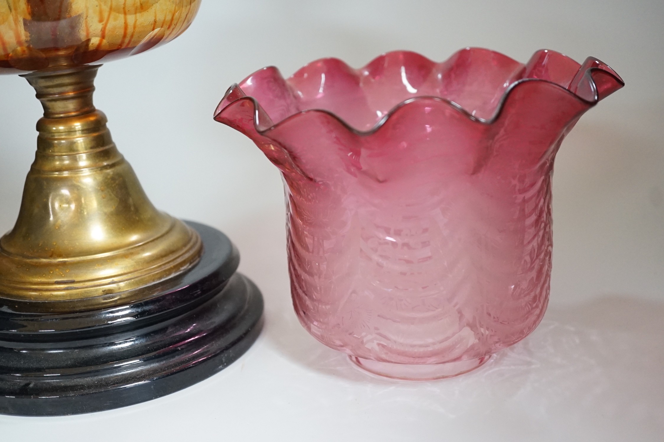 A Victorian brass and cranberry glass oil lamp